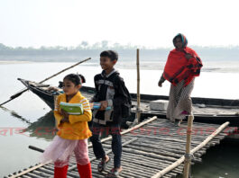 নতুন বই নিয়ে নদী পাড় হয়ে স্কুল থেকে ফিরছে শিশু সুমাইয়া